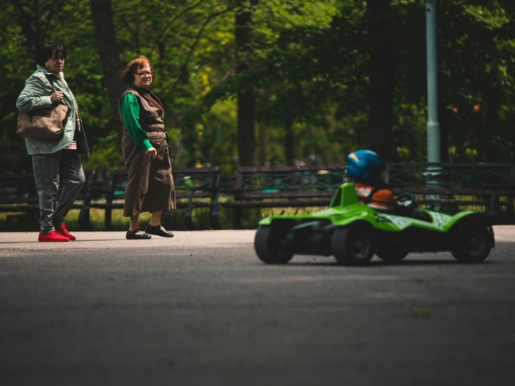 a  driving a go - kart on the road in front of another person