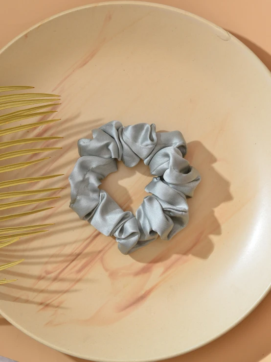 a decorative scrunchy hair piece sits next to a large comb