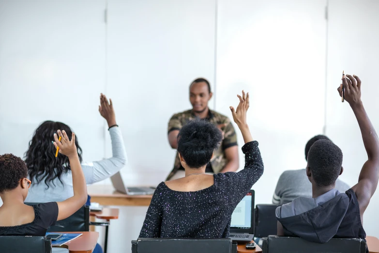 students sitting in front of a blackboard clapping