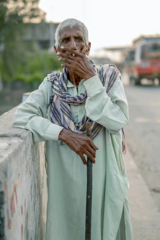 a man standing next to a wall with an umbrella