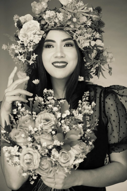 the woman smiles while holding flowers and a cigarette