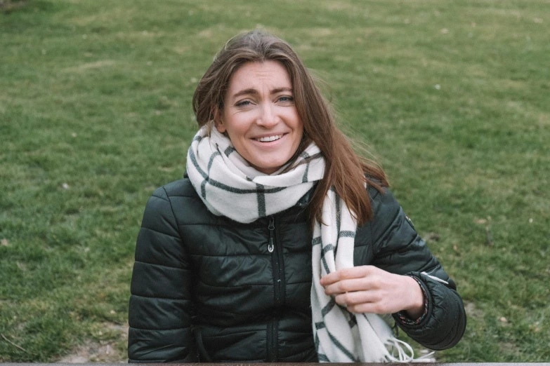 a woman wearing a black jacket with a white scarf