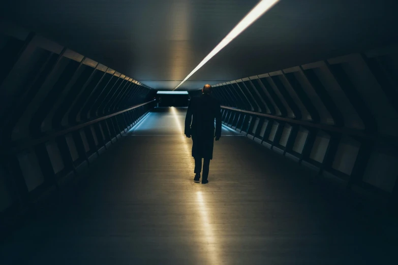 a person is walking through a dimly lit tunnel