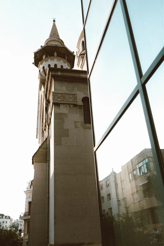 a mirror image of a very tall clock tower