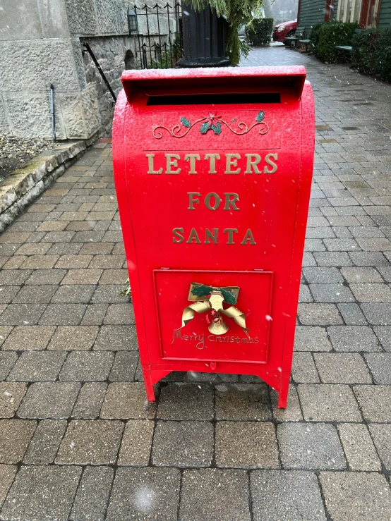 a red post box on a brick sidewalk