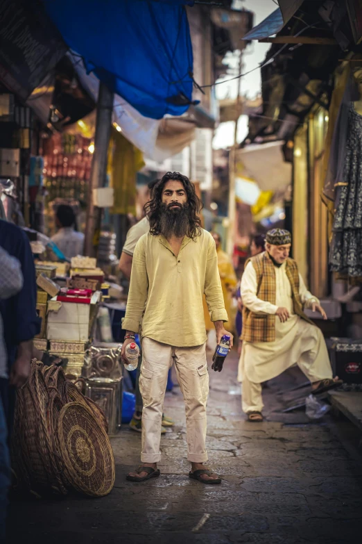 a man with long hair standing in a market area