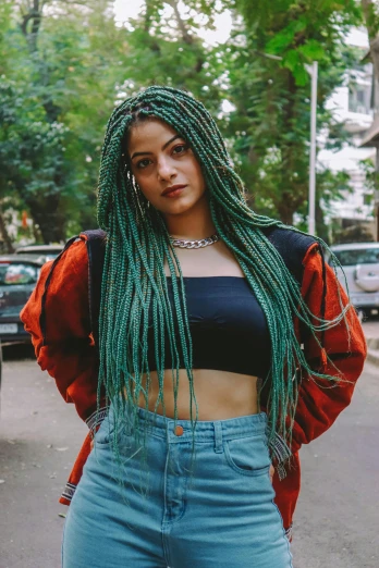 a young lady with green dreadlocks in the street