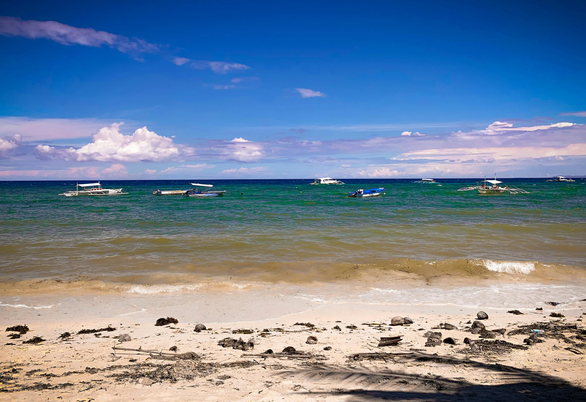 a beach that has boats in the water