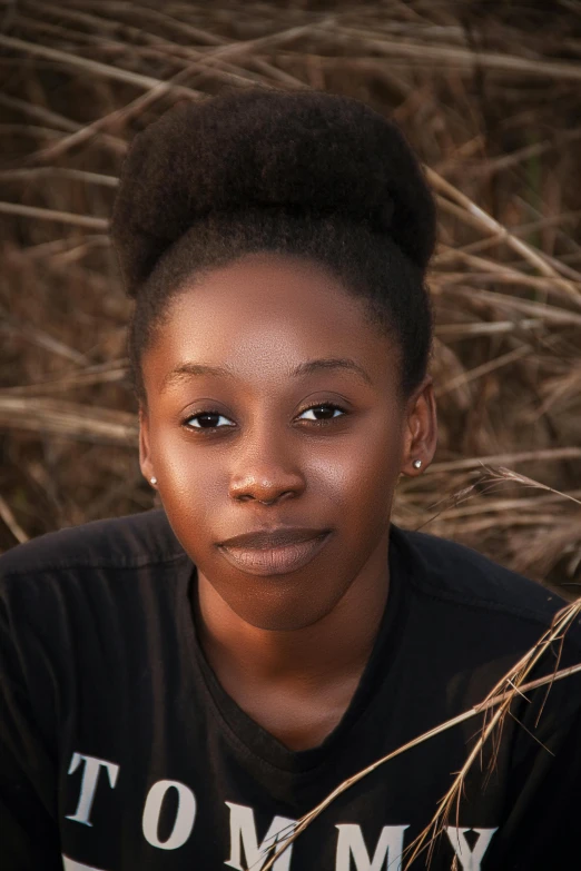 a woman is sitting in the grass and looking at the camera