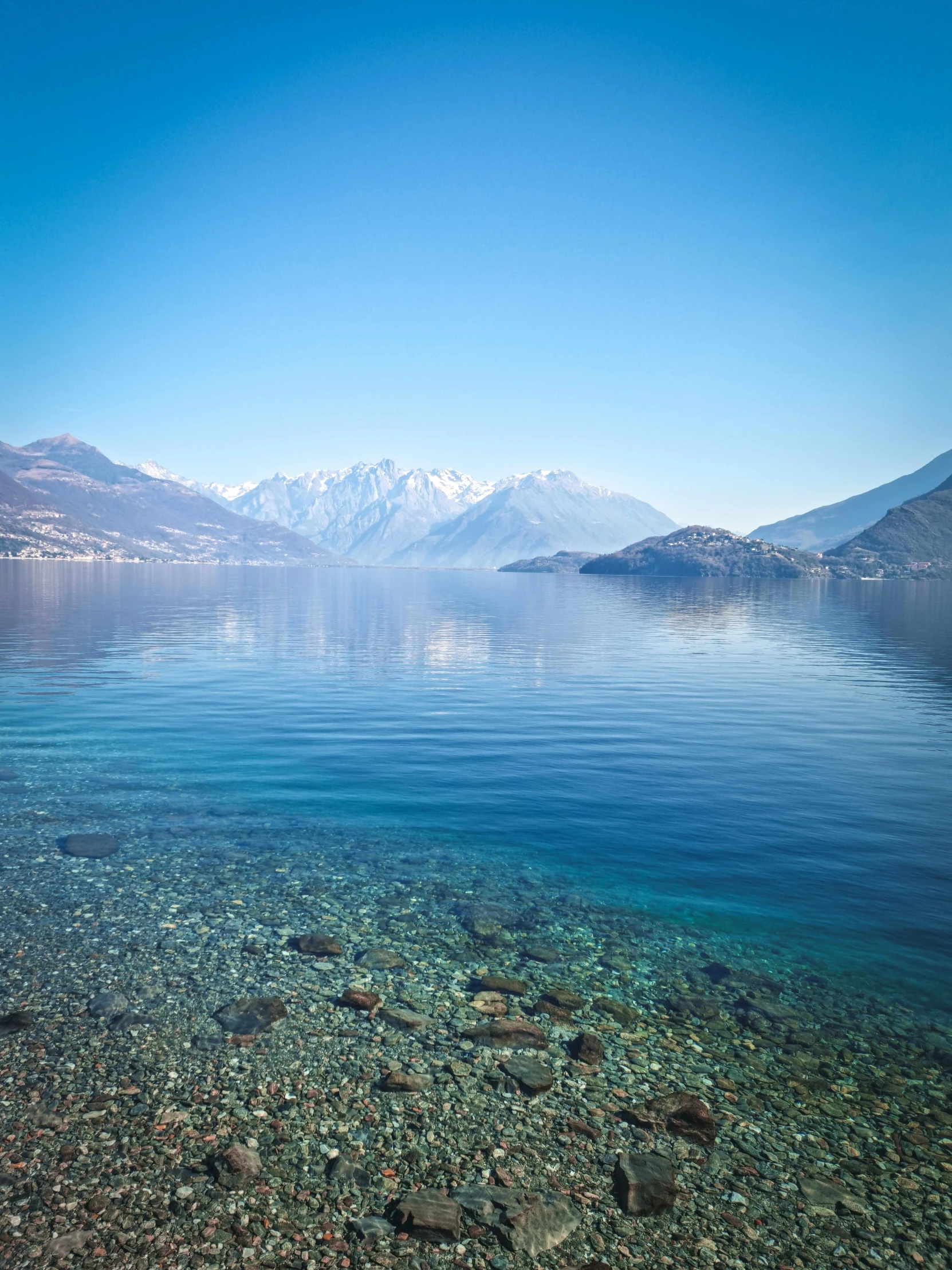 calm waters are surrounded by snow capped mountains