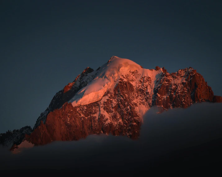 the snow capped mountain is glowing from its bright red glow