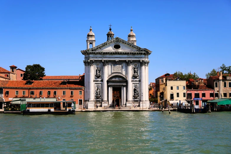 boats sit in front of a small structure by the water