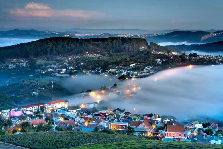 a town surrounded by fog on top of a mountain