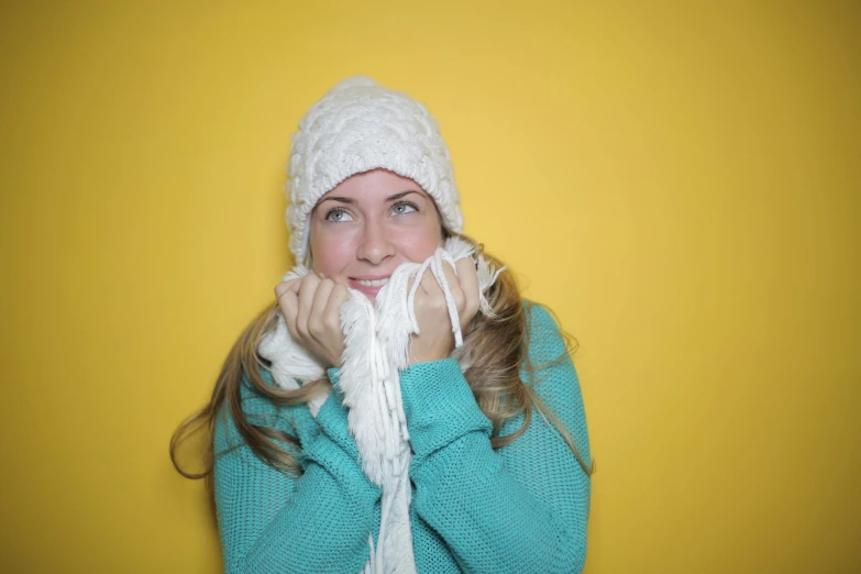 a woman is smiling while using a mitt to knit