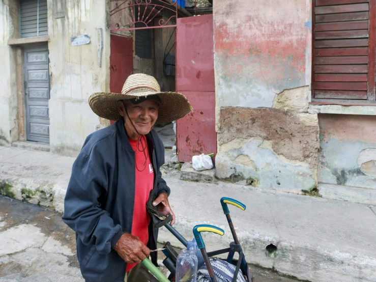 an old man wearing a hat, holding a stroller