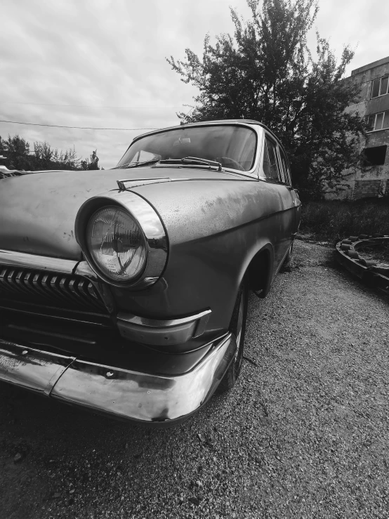 the front end of an old car sits empty in an abandoned yard