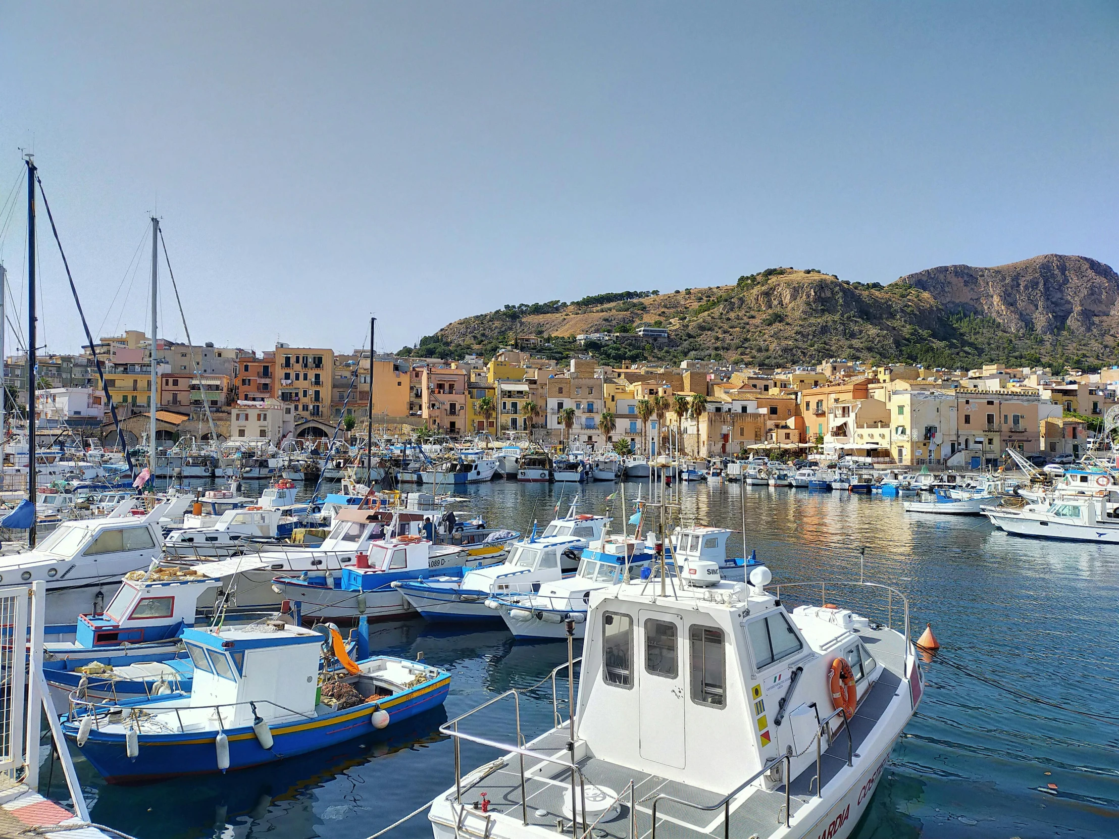 a harbor filled with lots of boats next to a mountain