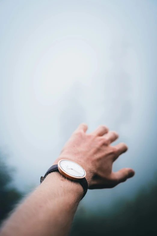 hand extended with wrist watch on it and blurry background