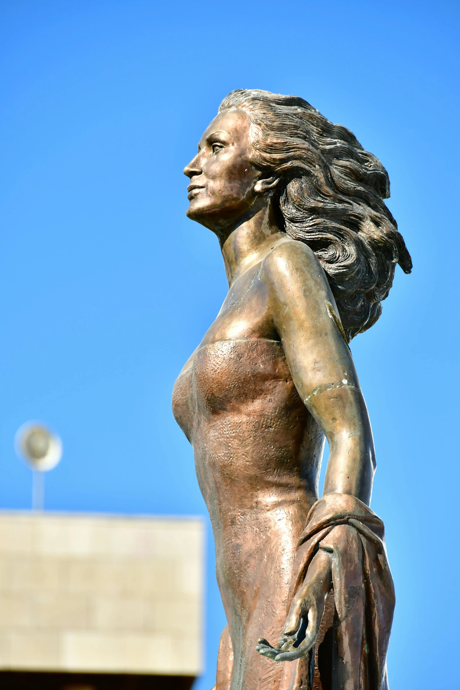 a golden statue is standing in front of a blue sky