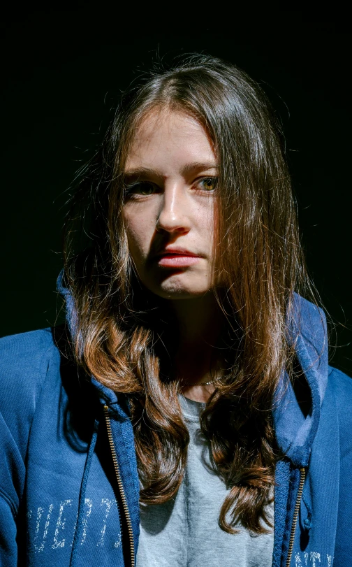 a woman with long hair stands in the dark