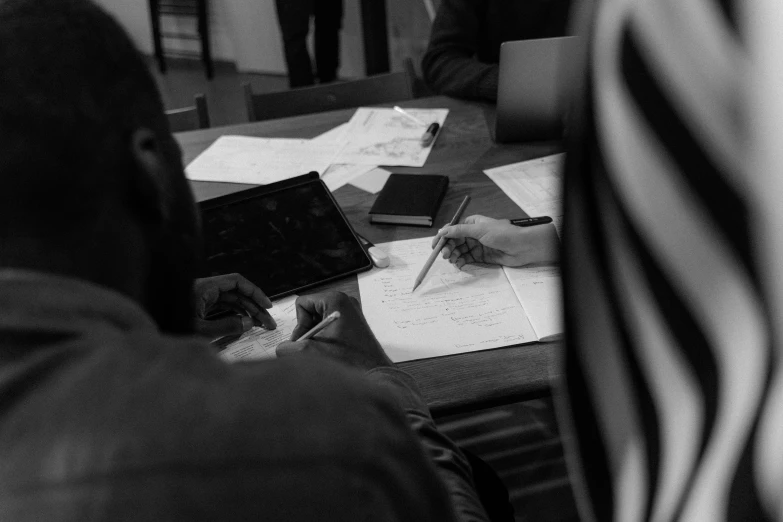 someone sitting at a table doing soing in a black and white po