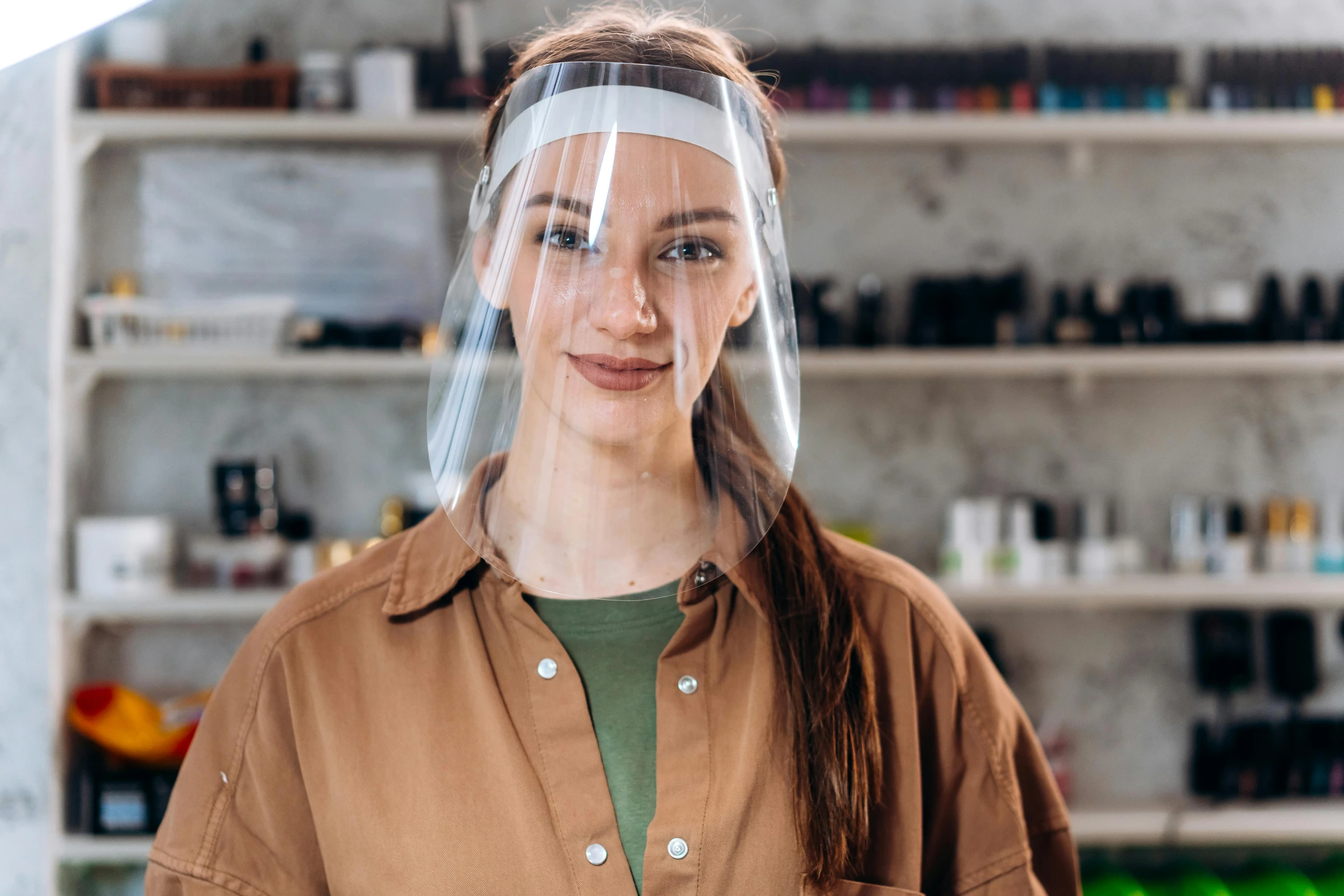 a woman wearing a clear helmet standing in a room with shelves