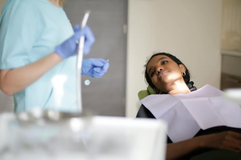 a woman getting her teeth checked with a dentist