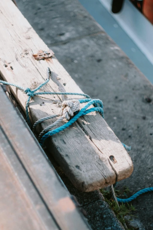 a piece of wood tied to a wooden bench