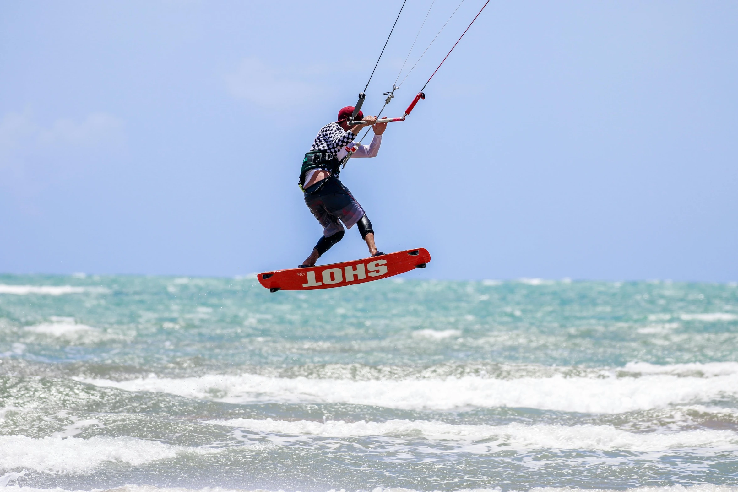 a man parasailing in the ocean with the help of someone holding on to ropes