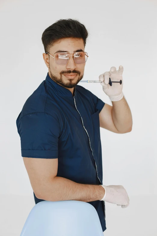 a man is holding a tube over his eye