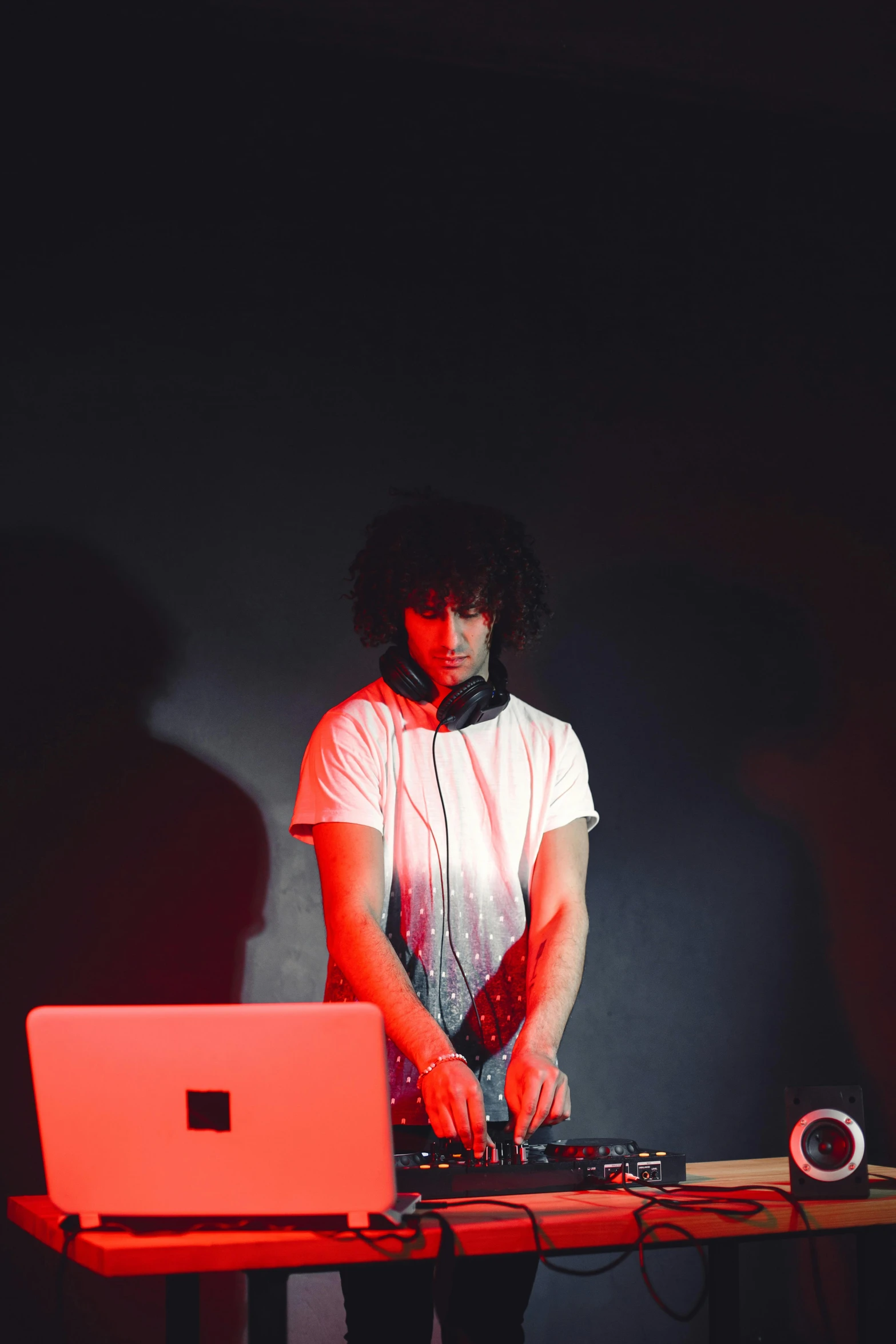 a person working at a table with headphones on and laptop