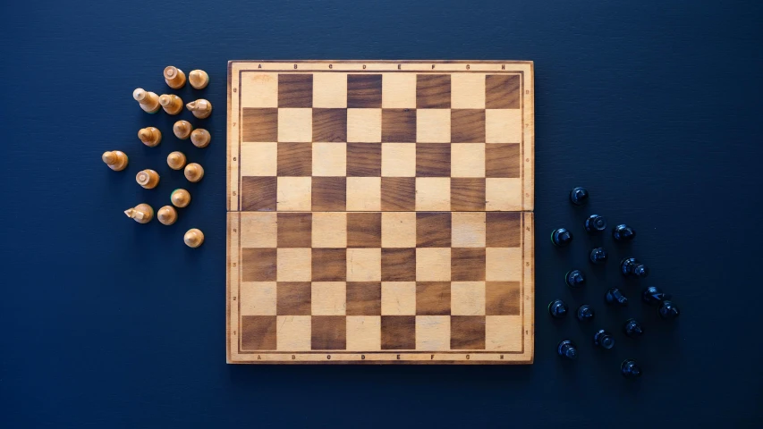 some little blue dolls next to a wooden chess set