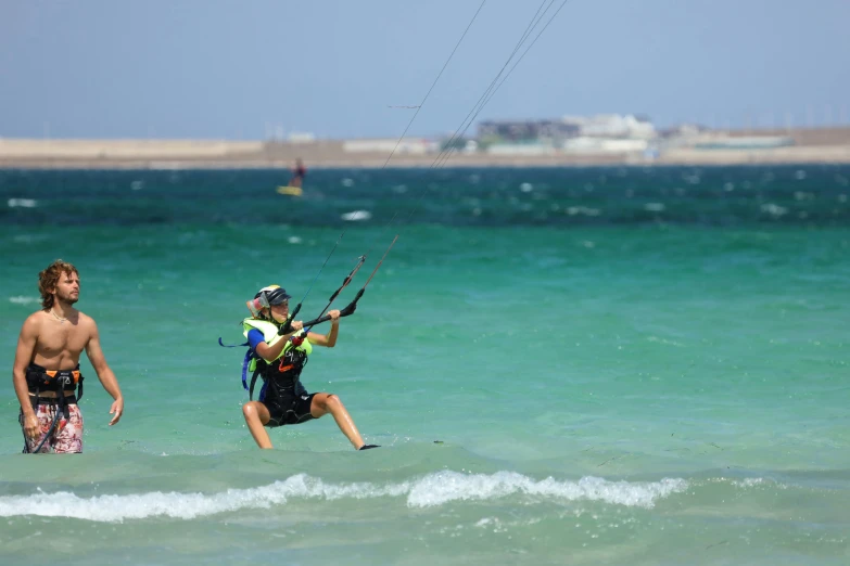 a person flying a kite over the water while on a surfboard