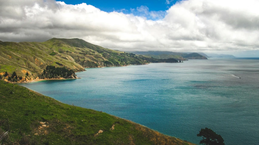 a scenic view of the ocean and mountain cliffs