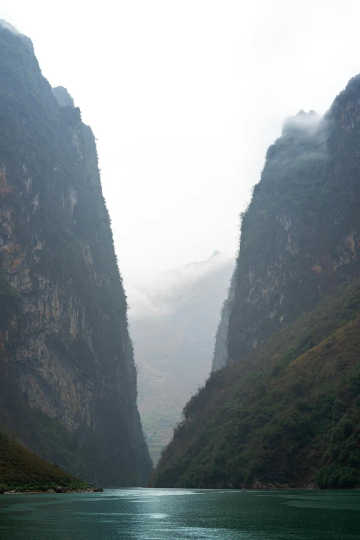 the steep rocky mountains are dotted with green vegetation