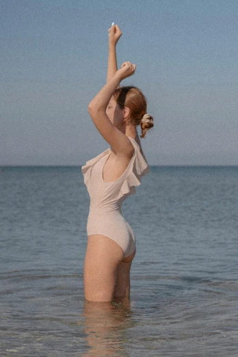 a woman is in the water with her arms outstretched