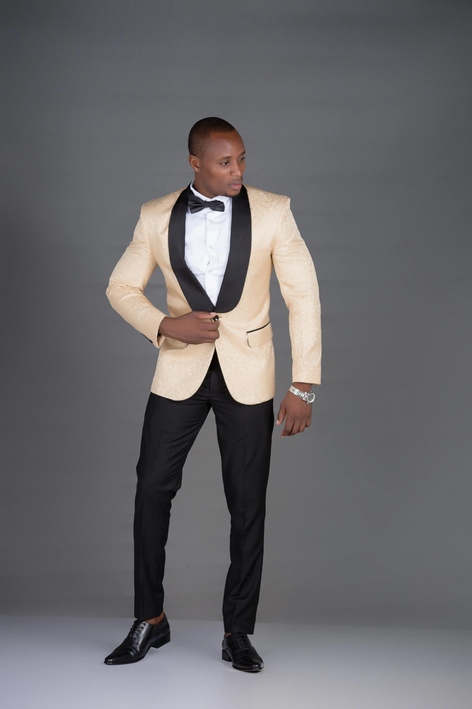 an african man in a beige tuxedo