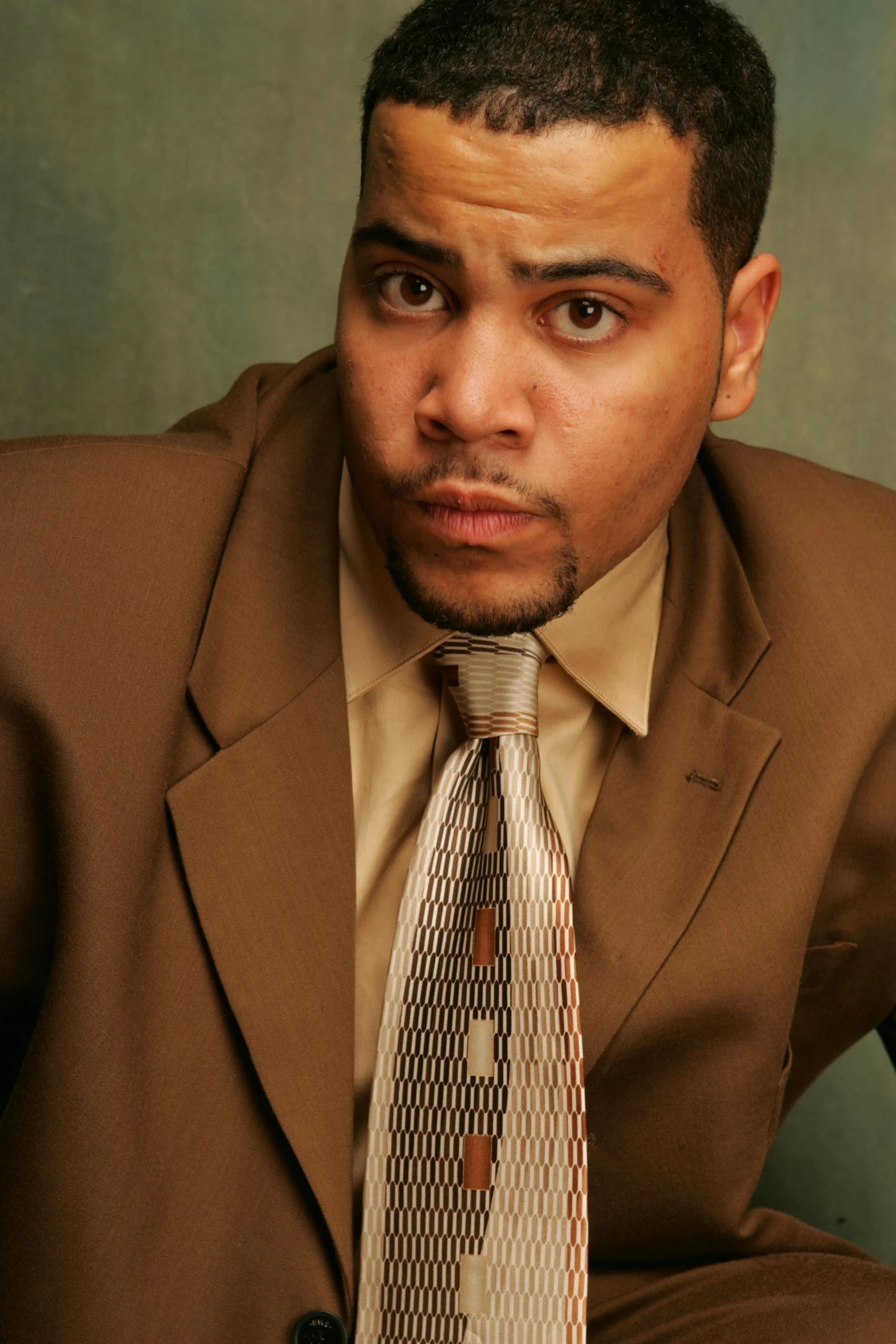 a man in brown suit jacket and tie