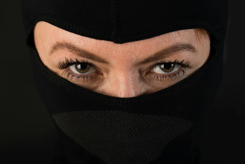 a woman wearing a black mask and dark eyes