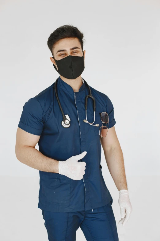 the young man in blue shirt and surgical mask holds out his hand