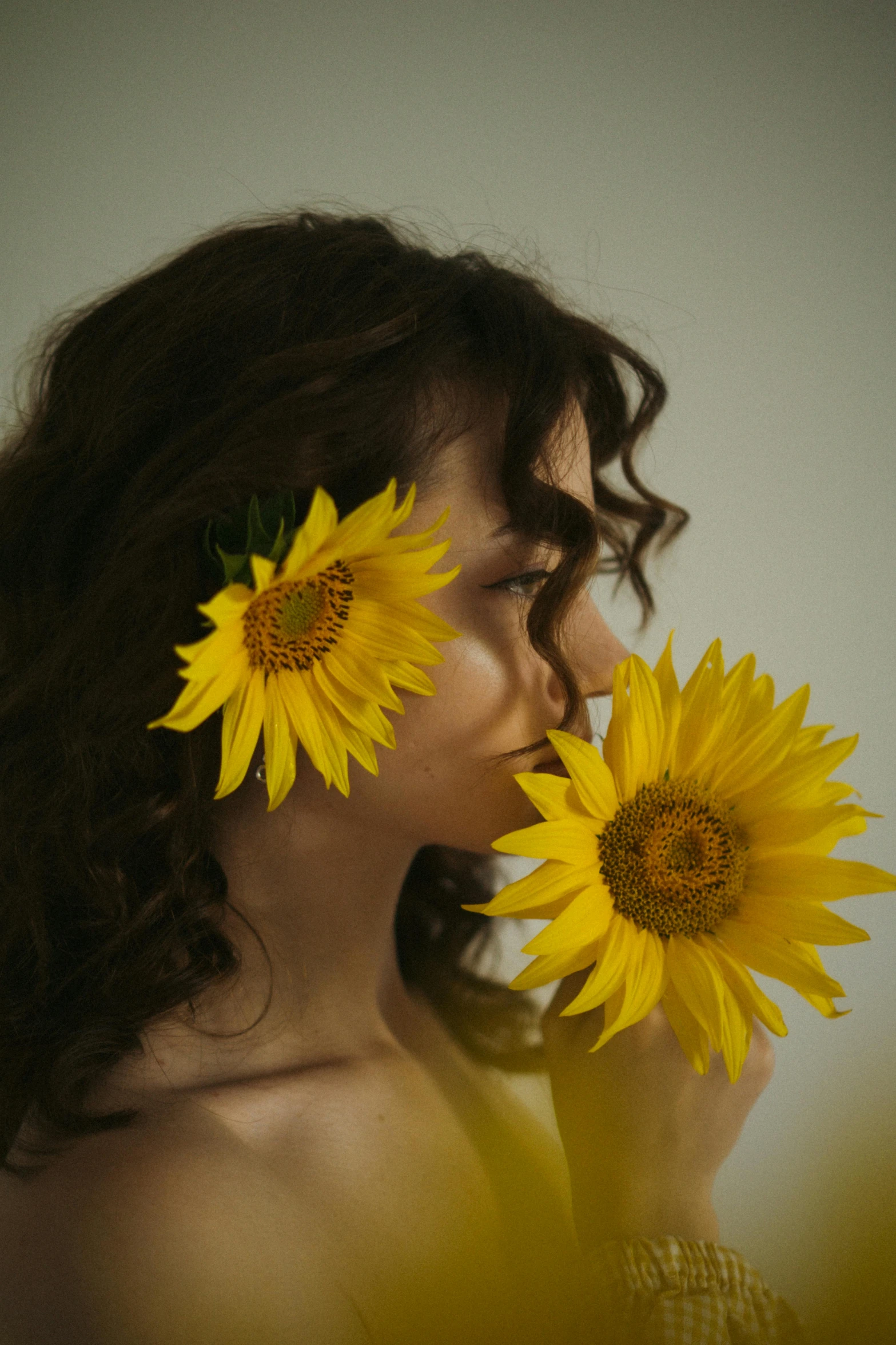 a woman holding two flowers with her mouth