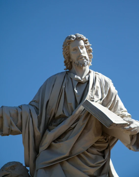 a large statue with a book in its hands