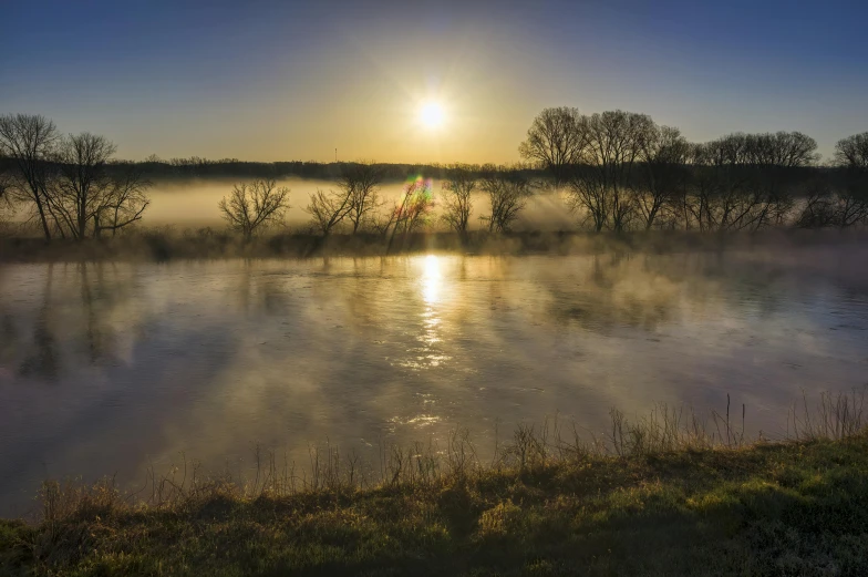 an image of the sun setting over the water