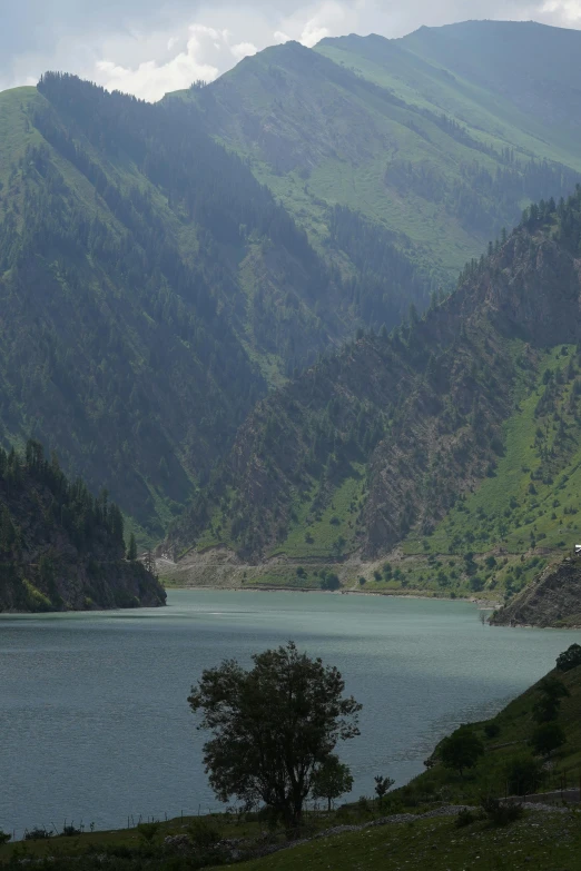 two green mountains rising above a lake in the distance