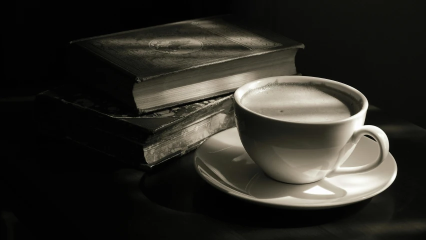 an coffee cup and a book sitting on a plate