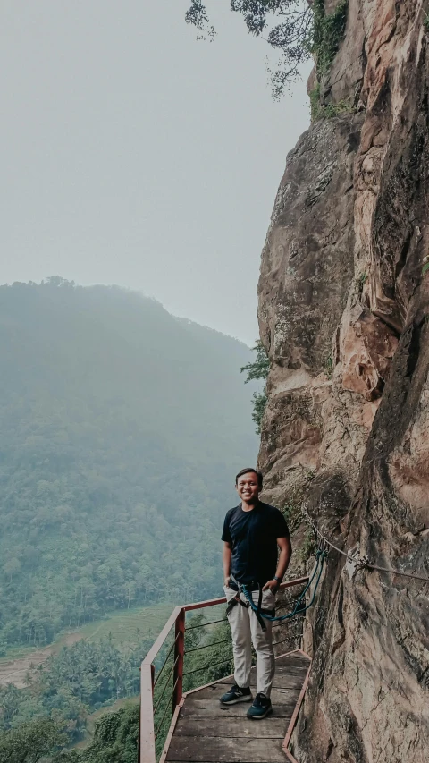 a man stands at the top of a mountain stairs