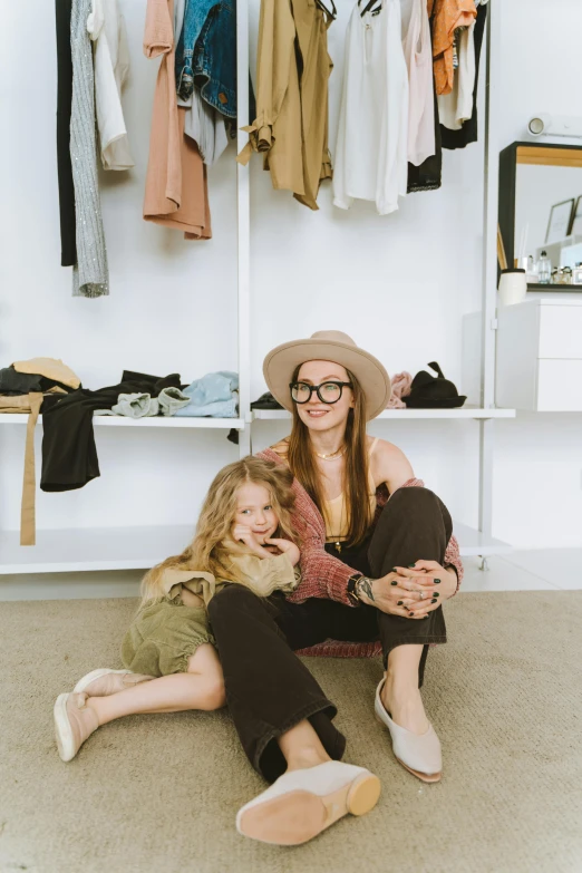 a girl sits on the floor with her mother