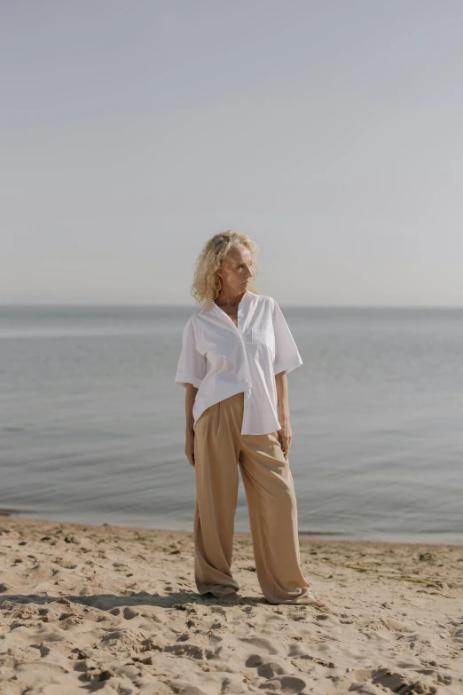 a woman is on the beach looking at soing