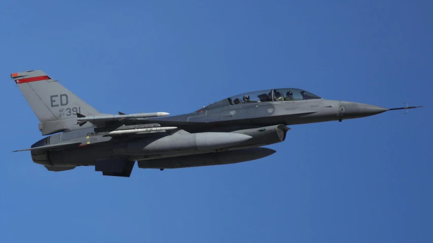 an fighter jet flying in a blue sky