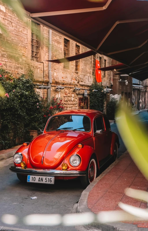 a red car parked in the street near a building